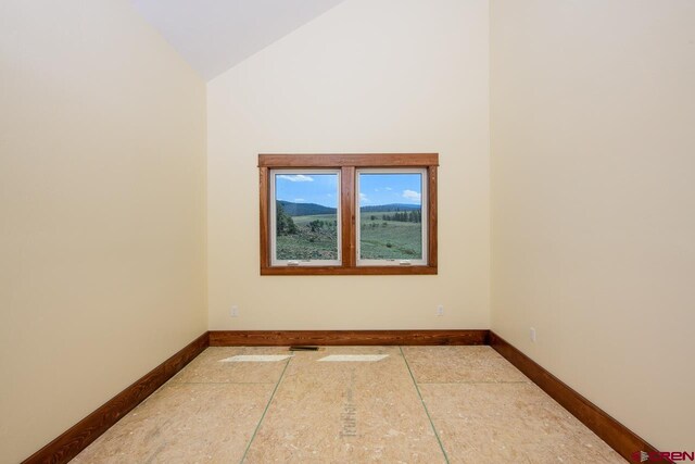 unfurnished room featuring vaulted ceiling