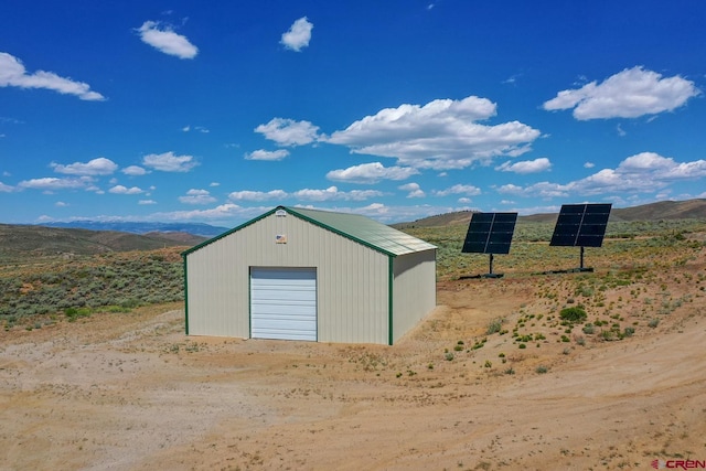 view of outdoor structure featuring a mountain view and a garage