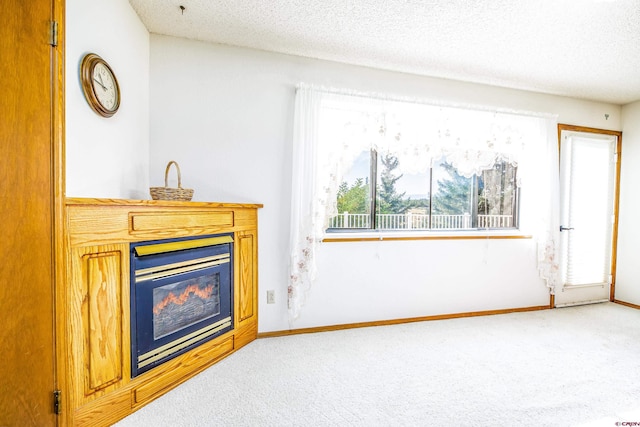 living room with carpet flooring, a wealth of natural light, and a textured ceiling