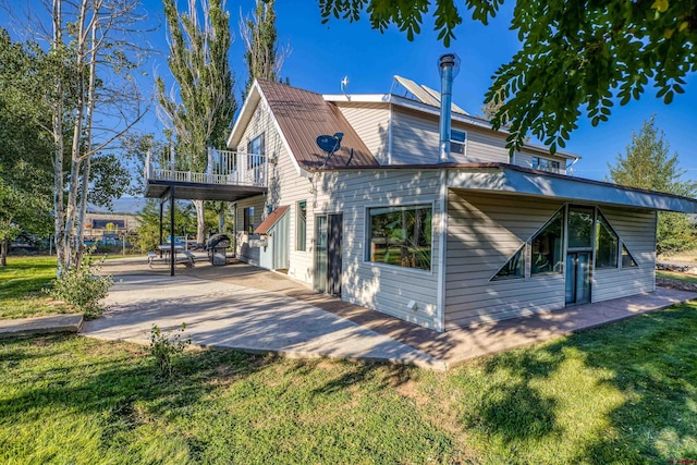 back of property with a yard and a balcony