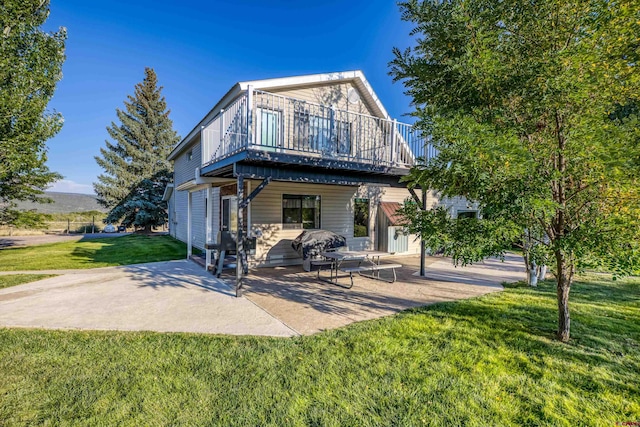 rear view of house featuring a lawn, a patio area, and a deck