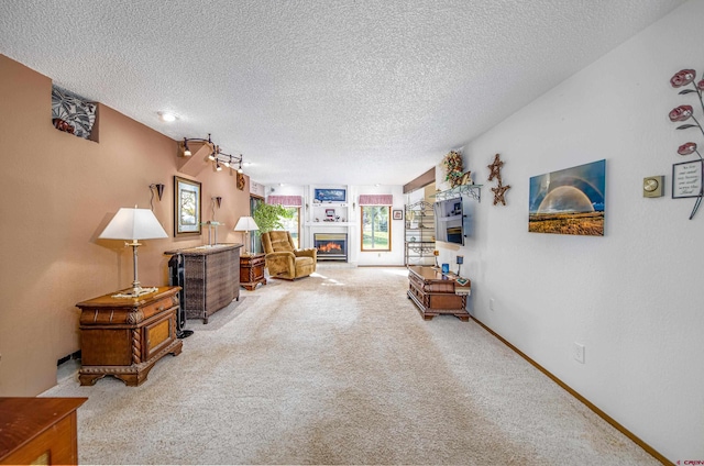 carpeted living room with track lighting and a textured ceiling