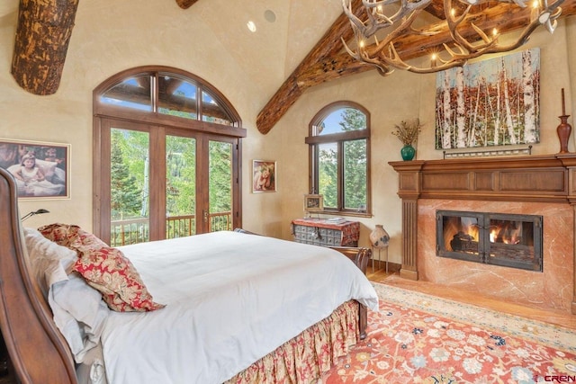 bedroom with access to outside and vaulted ceiling with beams