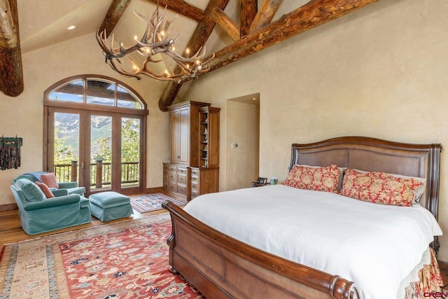 bedroom with access to outside, hardwood / wood-style flooring, beam ceiling, and high vaulted ceiling