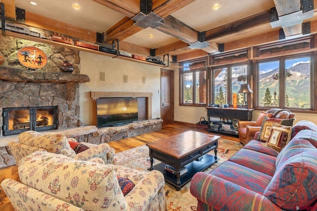 living room featuring a mountain view, a fireplace, beam ceiling, and hardwood / wood-style floors