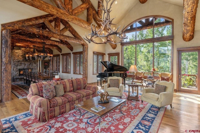 living room with high vaulted ceiling, plenty of natural light, and light hardwood / wood-style floors