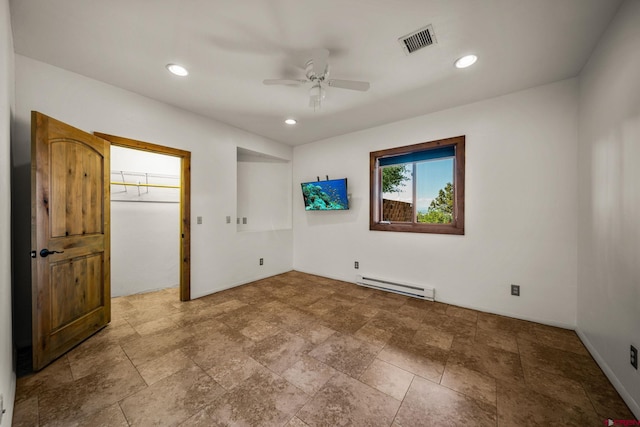 unfurnished bedroom featuring a baseboard radiator, ceiling fan, and a spacious closet