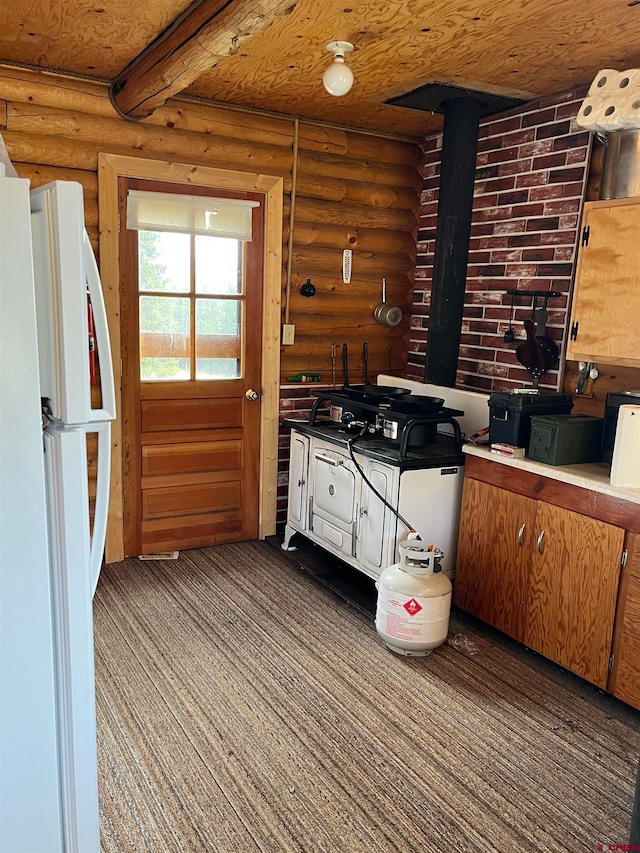 kitchen with log walls, wooden ceiling, and white refrigerator