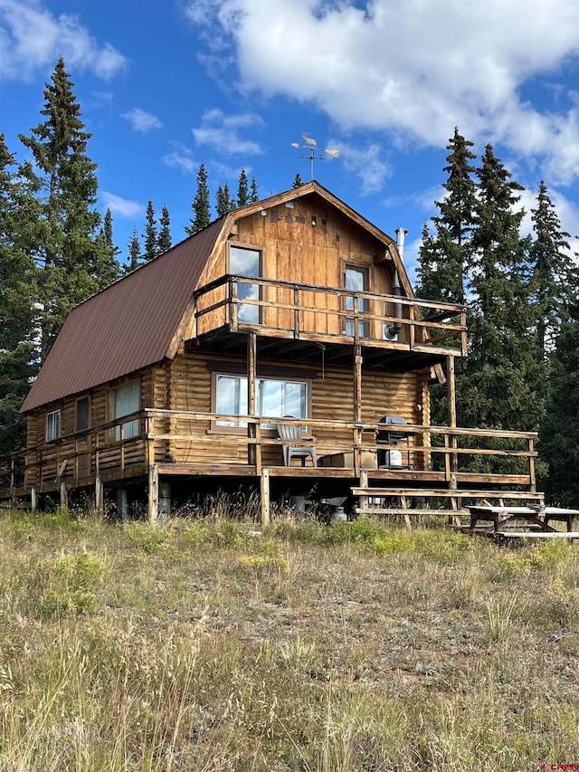 rear view of property featuring a deck