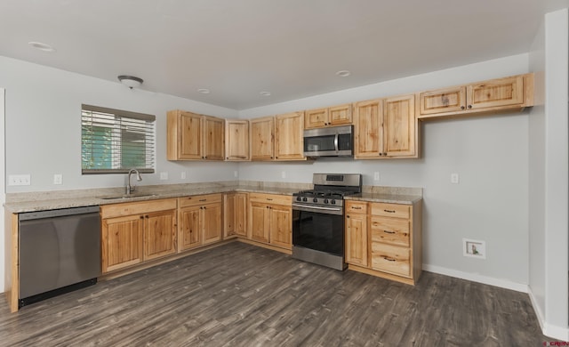 kitchen with dark wood-type flooring, stainless steel appliances, sink, and light stone countertops