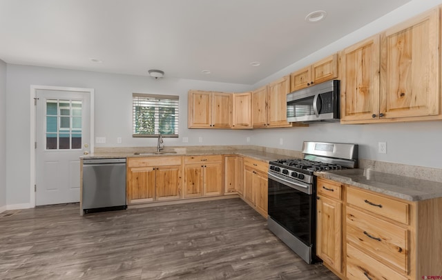 kitchen with dark hardwood / wood-style flooring, light brown cabinetry, light stone counters, sink, and appliances with stainless steel finishes