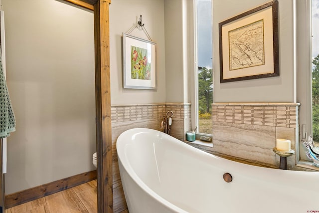 bathroom featuring toilet, hardwood / wood-style flooring, and a bathtub