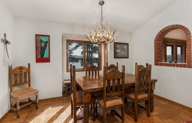 tiled dining room with a chandelier