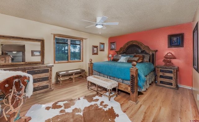 bedroom with a textured ceiling, ceiling fan, and light wood-type flooring