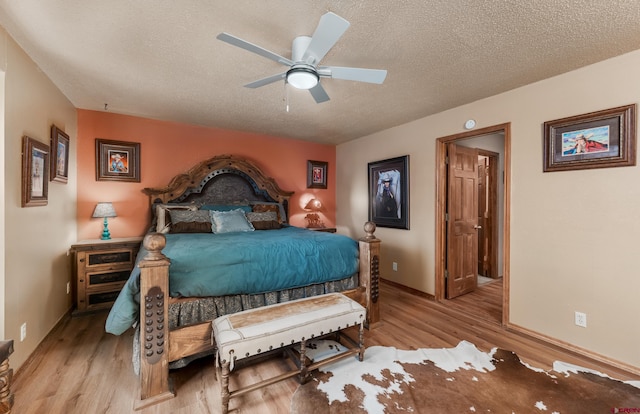 bedroom with a textured ceiling, ceiling fan, and light hardwood / wood-style floors