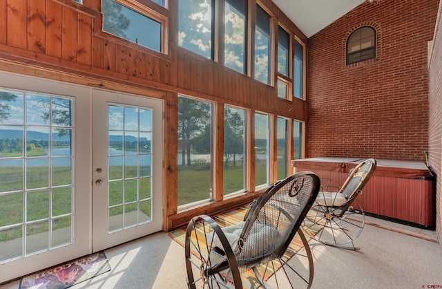 sunroom with a water view, a healthy amount of sunlight, and french doors