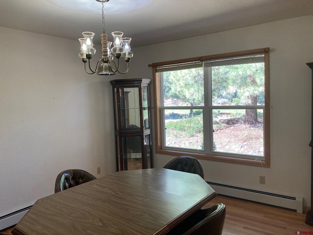 dining space featuring a baseboard heating unit, wood-type flooring, and a chandelier