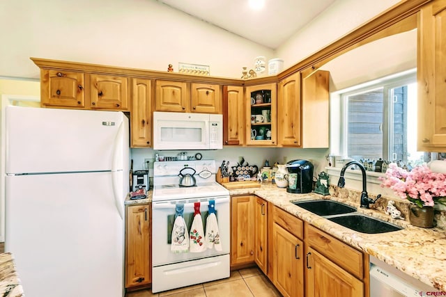 kitchen with light stone countertops, white appliances, light tile patterned floors, sink, and lofted ceiling