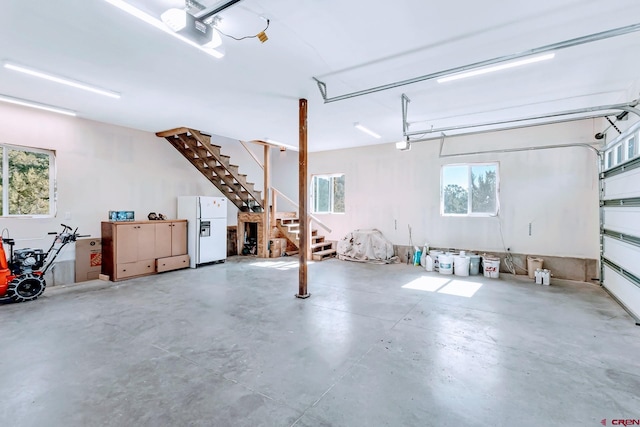 garage featuring white refrigerator and a garage door opener