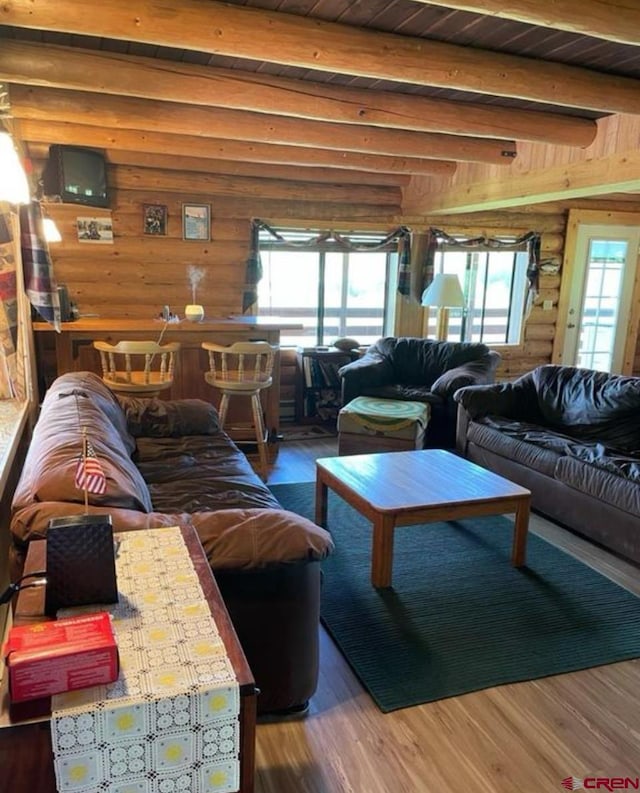 living room with wood-type flooring, beam ceiling, wood walls, and wooden ceiling