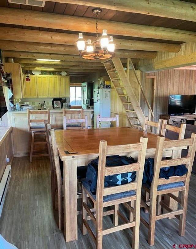 dining area with wood ceiling, dark wood-type flooring, baseboard heating, beam ceiling, and an inviting chandelier