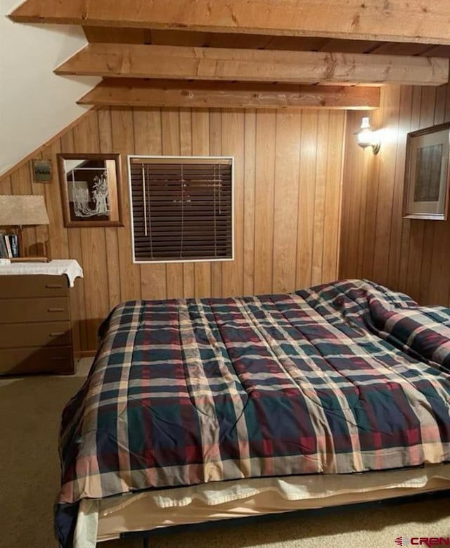 carpeted bedroom featuring wooden walls and beamed ceiling