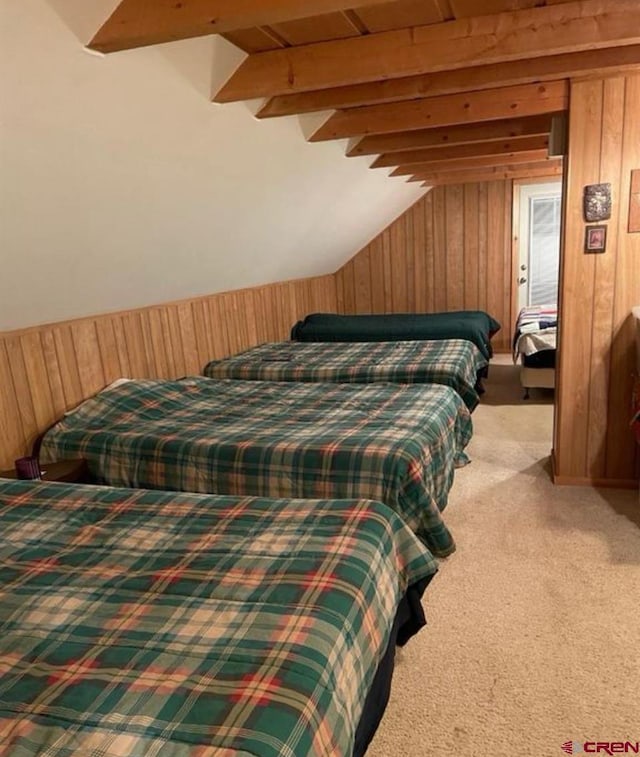 carpeted bedroom with wooden walls and lofted ceiling with beams