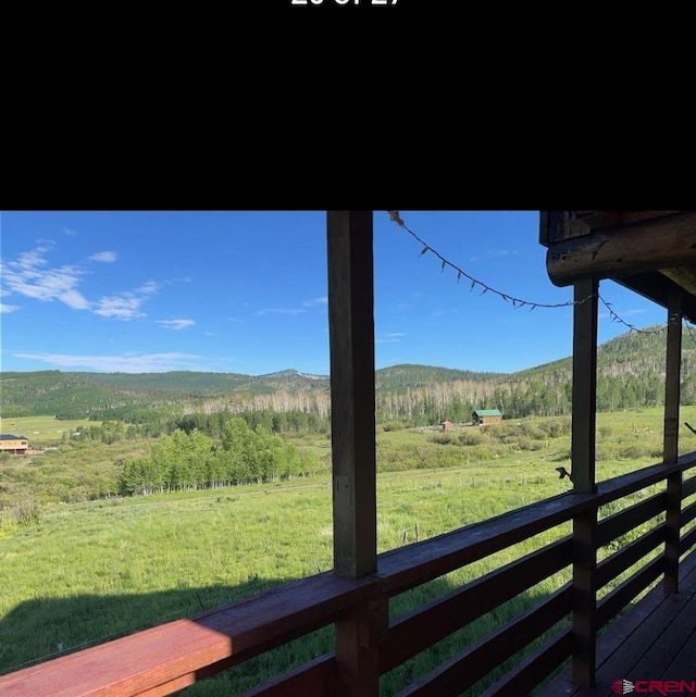 view of yard featuring a deck with mountain view and a rural view