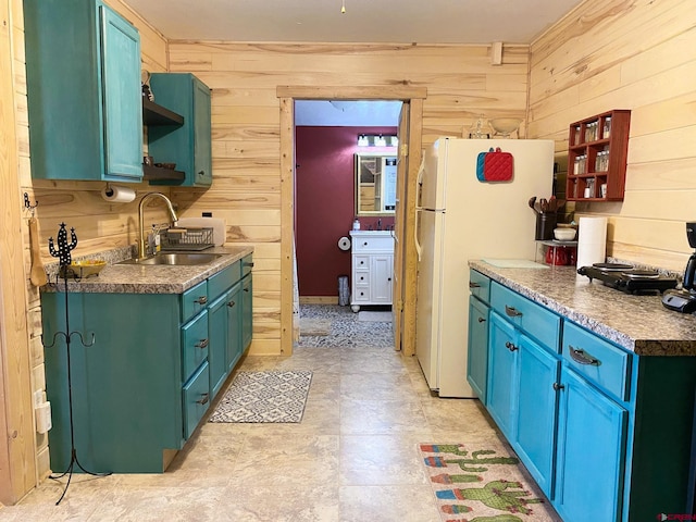 kitchen featuring white refrigerator, sink, and wooden walls