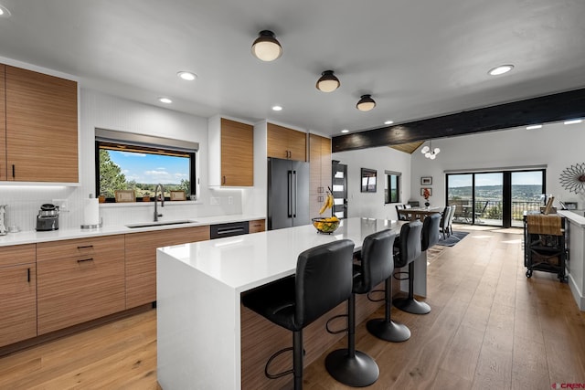 kitchen featuring a wealth of natural light, beamed ceiling, a kitchen island, and a breakfast bar area