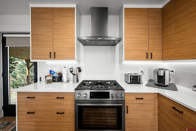 kitchen with decorative backsplash, high end range, and wall chimney range hood