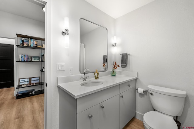 bathroom featuring vanity, toilet, and hardwood / wood-style flooring