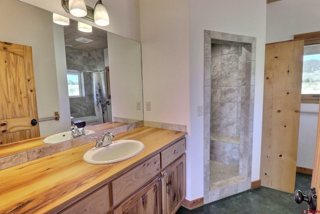 bathroom featuring a tile shower, concrete floors, and vanity