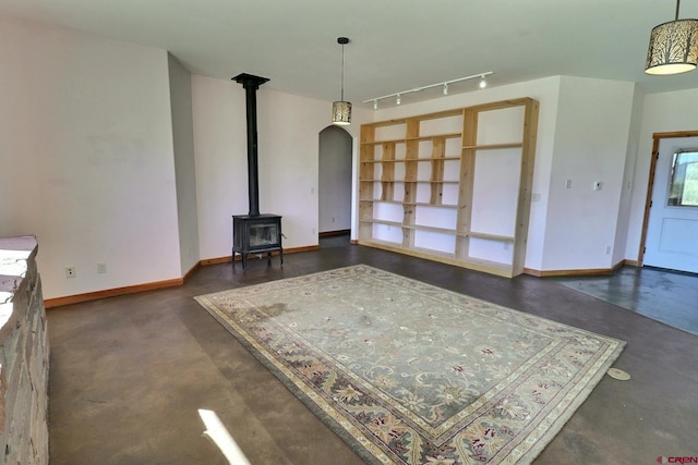 interior space with a wood stove and track lighting