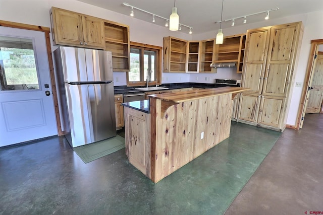 kitchen with decorative light fixtures, rail lighting, exhaust hood, appliances with stainless steel finishes, and a center island