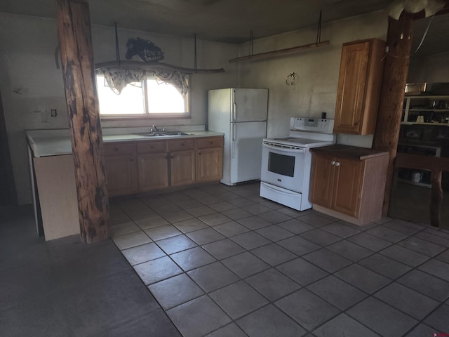 kitchen featuring white appliances, light tile patterned floors, and sink