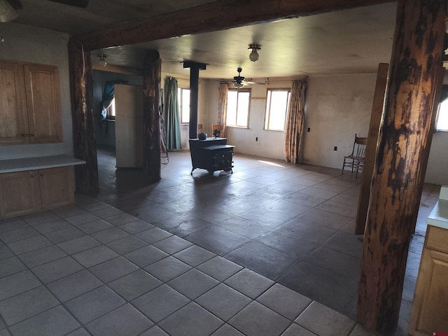 interior space with ceiling fan and a wood stove