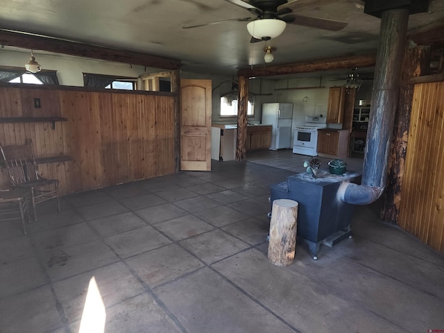 garage featuring wood walls, ceiling fan, and white fridge