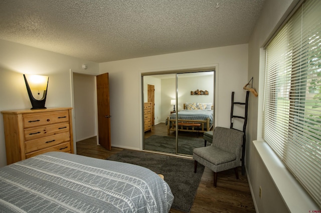 bedroom featuring a textured ceiling, a closet, and dark hardwood / wood-style floors