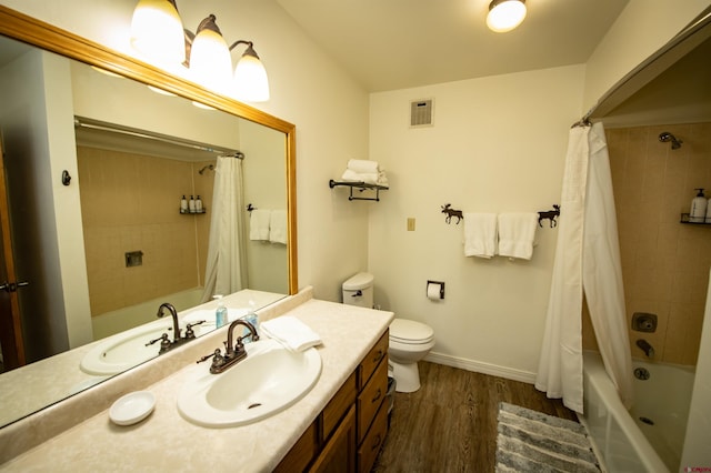 full bathroom featuring wood-type flooring, shower / bath combo, vanity, and toilet