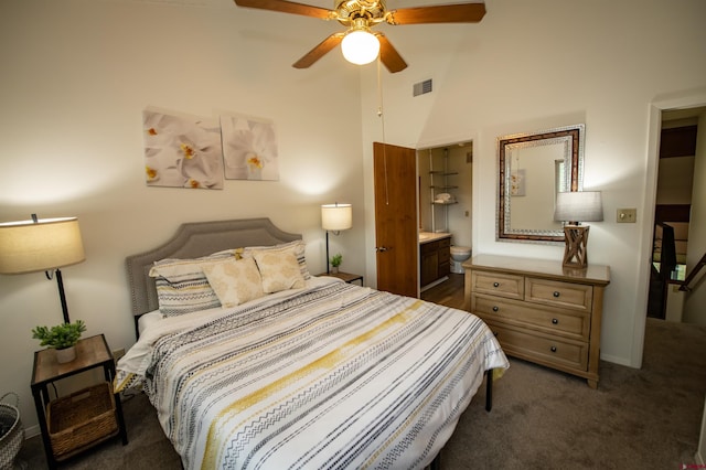 bedroom featuring ceiling fan, connected bathroom, a high ceiling, and dark carpet