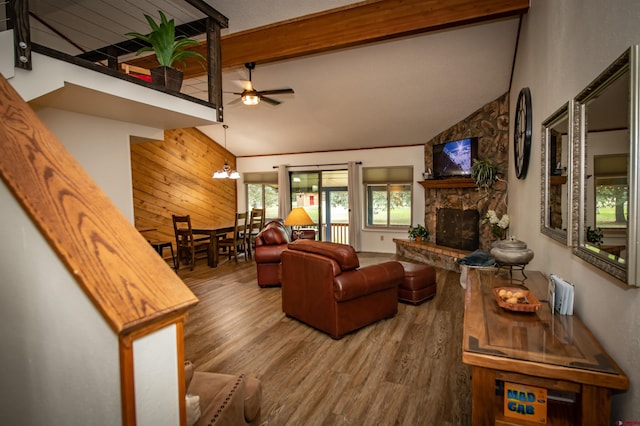 living room with high vaulted ceiling, wood-type flooring, ceiling fan, and a stone fireplace