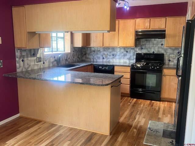 kitchen with sink, kitchen peninsula, black appliances, range hood, and light wood-type flooring