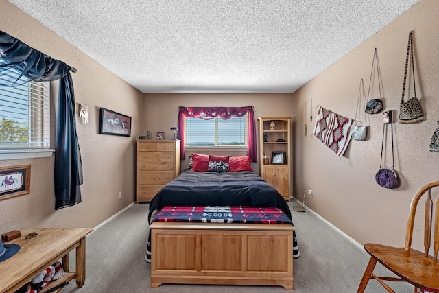 carpeted bedroom with multiple windows and a textured ceiling