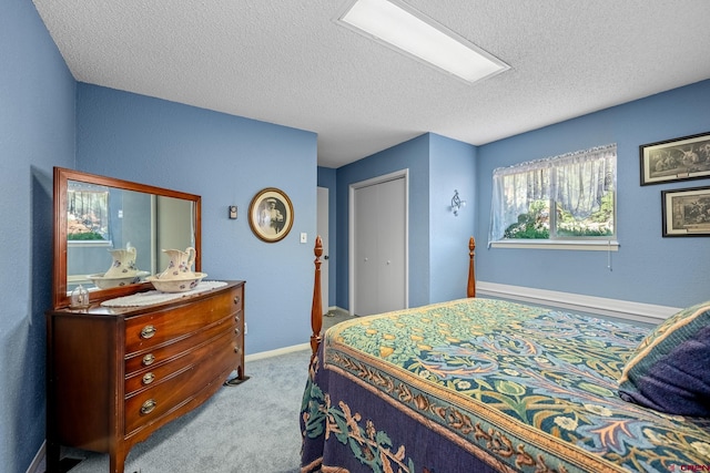 carpeted bedroom with a textured ceiling and a closet