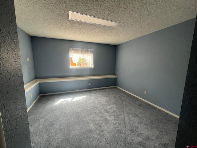 carpeted empty room featuring a textured ceiling