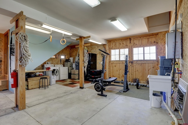 workout room featuring wood walls and independent washer and dryer