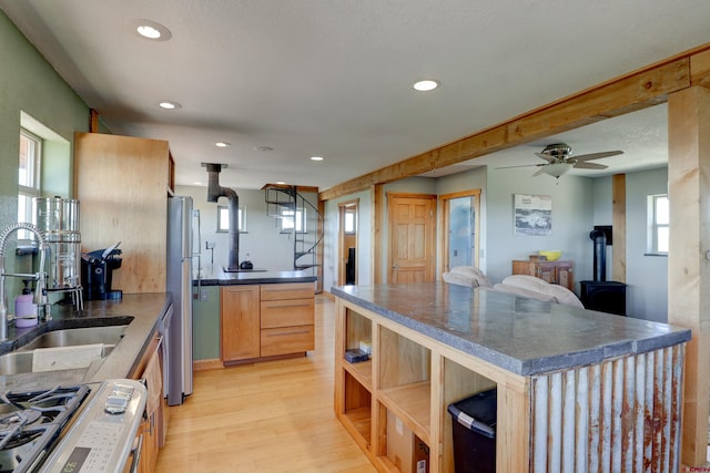 kitchen featuring light wood-type flooring, a healthy amount of sunlight, appliances with stainless steel finishes, and ceiling fan