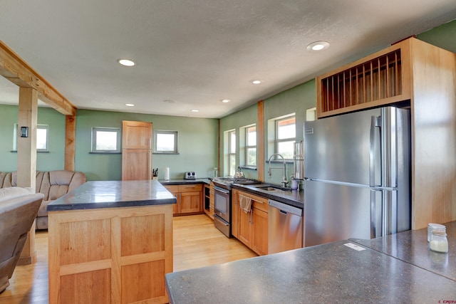 kitchen featuring a wealth of natural light, appliances with stainless steel finishes, light wood-type flooring, and sink