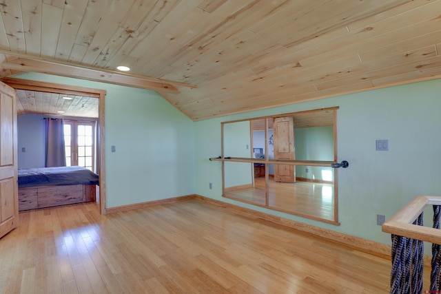 empty room featuring light hardwood / wood-style flooring, wood ceiling, and lofted ceiling